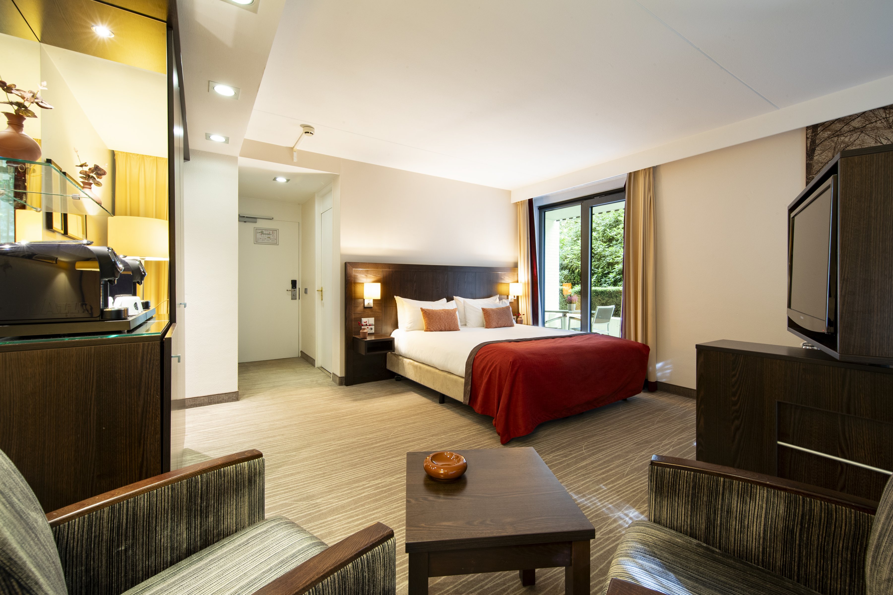 Comfortabele executive room met koffiezetapparaat en uitzicht op de bossen bij Hotel De Bovenste Molen.